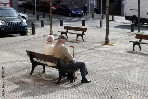 Ageing couple sat on a bench
