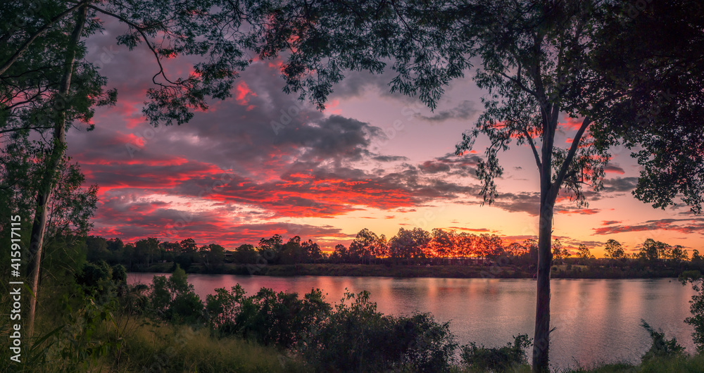Fototapeta premium Beautiful Panoramic Riverside Sunset with Dramatic Sky and Reflections