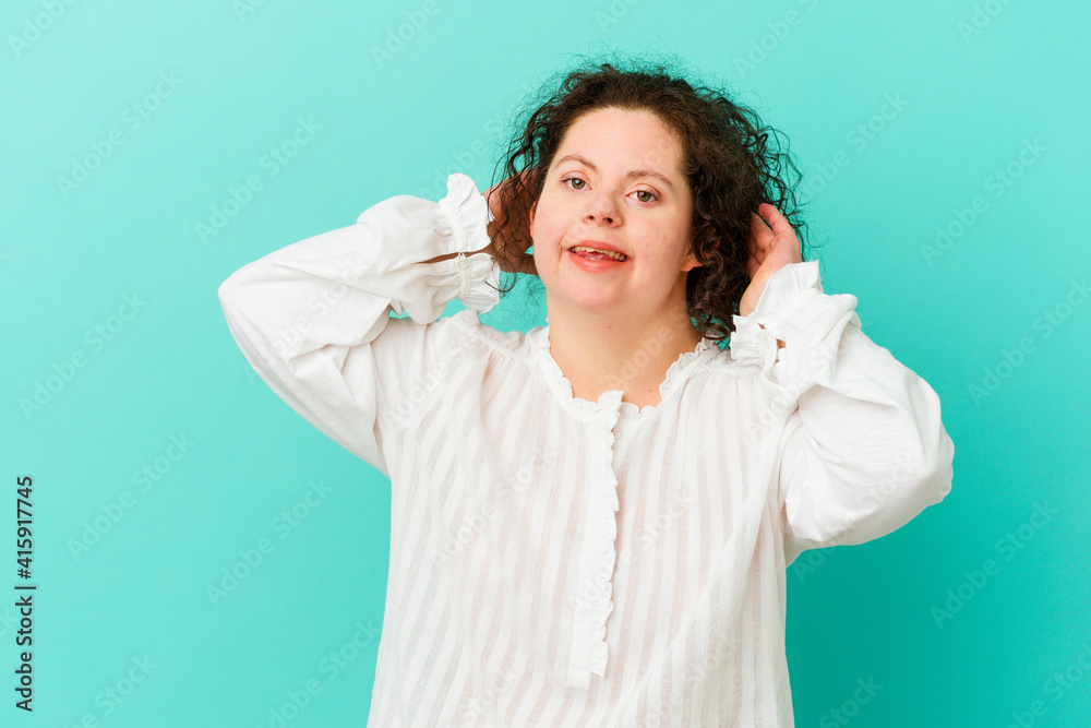 Woman with Down syndrome isolated feeling confident, with hands behind the head. Woman with Down syndrome isolated feeling confident, with hands behind the head.