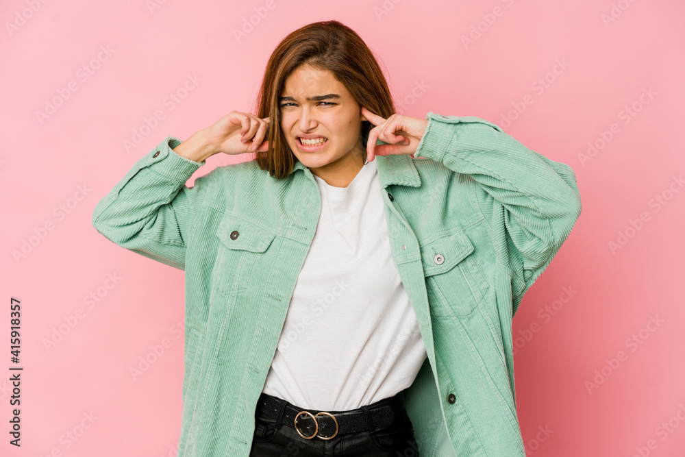 Young skinny caucasian teenager girl covering ears with fingers, stressed and desperate by a loudly ambient. Young skinny caucasian teenager girl covering ears with fingers, stressed and desperate by a loudly ambient.