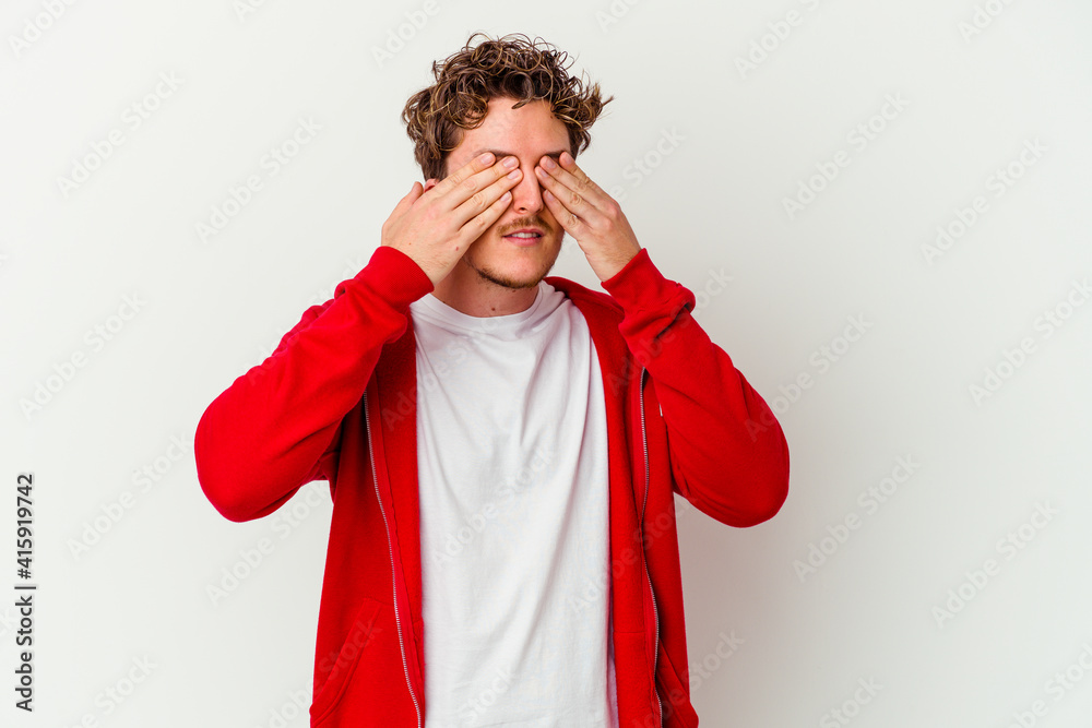 Young caucasian man isolated on white background afraid covering eyes with hands.