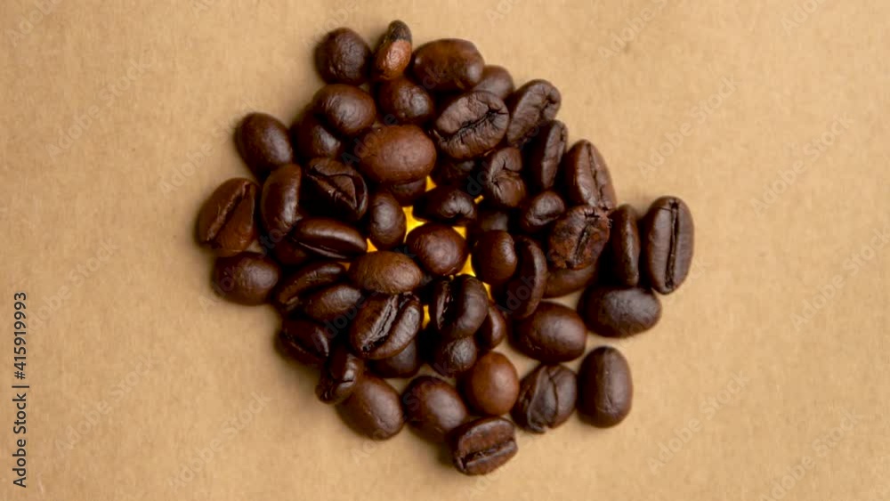 Pile of coffee beans rotates in a circle close up filming from above Pile of coffee beans rotates in a circle close up filming from above