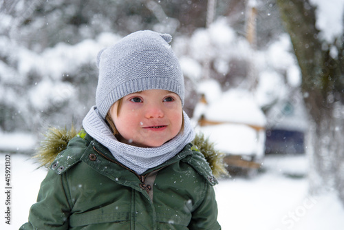 Foto Portrait of Down syndrome boy in a winter outfit.
