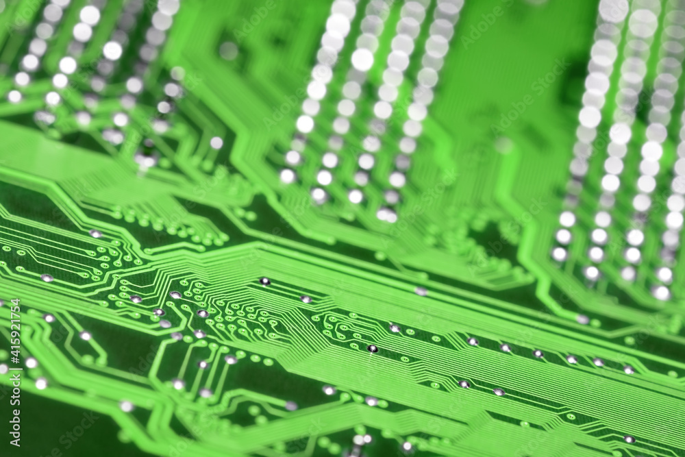 Green printed circuit board with selective focus and shiny pins bokeh background, diagonal composition