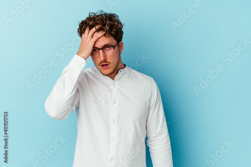 Young caucasian business man isolated on blue background tired and very sleepy keeping hand on head.