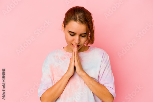 Young arab mixed race woman praying, showing devotion, religious person looking for divine inspiration.