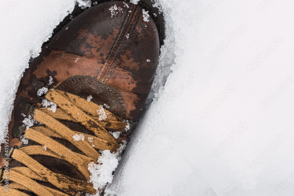 Brown shoe sunk in the snow