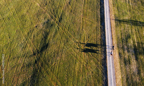 Luftaufnahme mit einer Drohne von zwei Reiterinnen auf Pferden mit einem lustigen Schatten