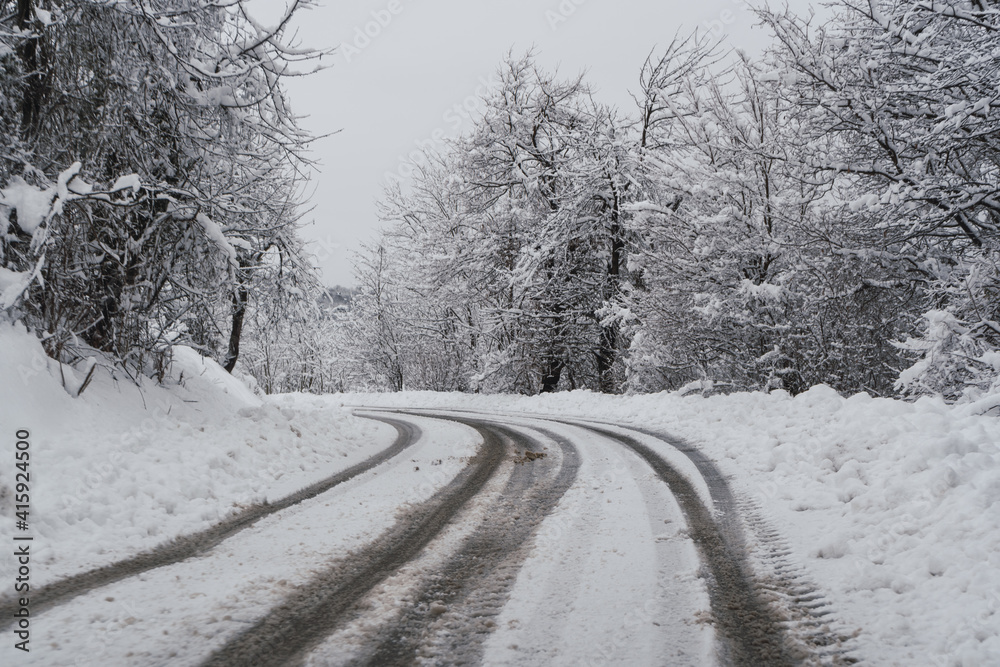 Snow-covered road with trees on the sides. Snow-covered road with trees on the sides.