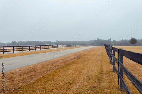 Rural road. Strong fog and country farm in the morning. Wooden fence. 