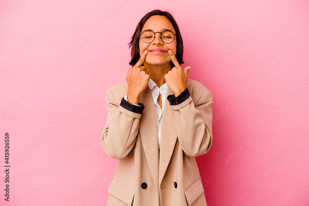 Young business mixed race woman isolated on pink background doubting between two options. Young business mixed race woman isolated on pink background doubting between two options.