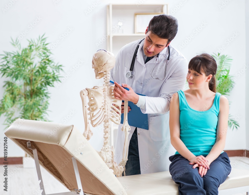 Fototapeta premium Doctor showing type of injury on skeleton to patient