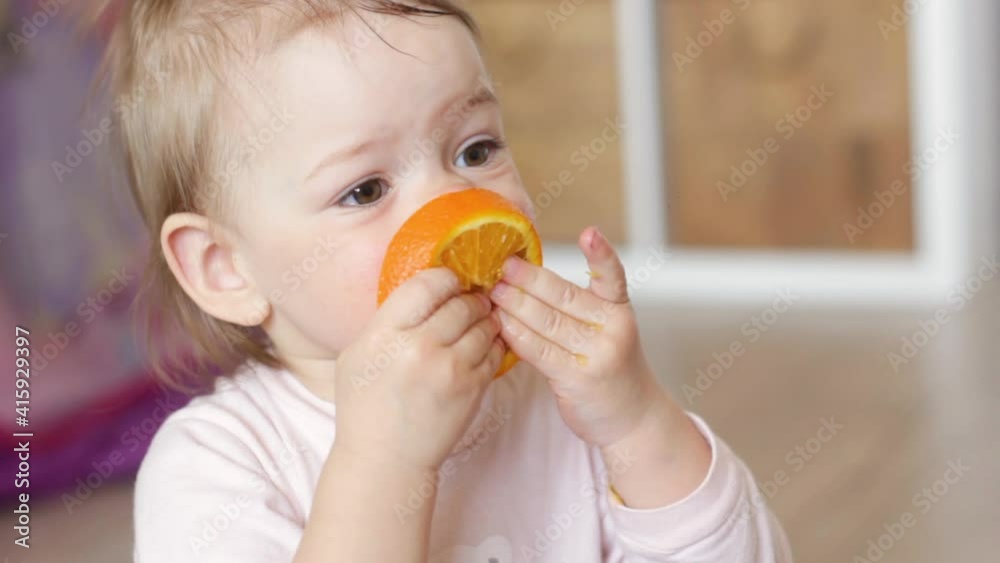 little girl eating an orange, close-up portrait little girl eating an orange, close-up portrait
