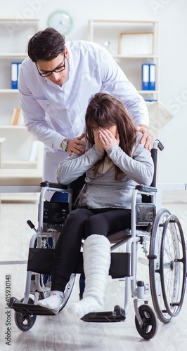 Male doctor examining female patient on wheelchair
