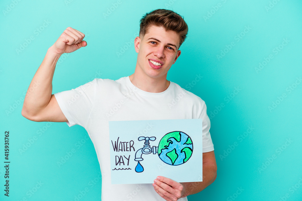 Young caucasian man holding a water day placard isolated on blue background