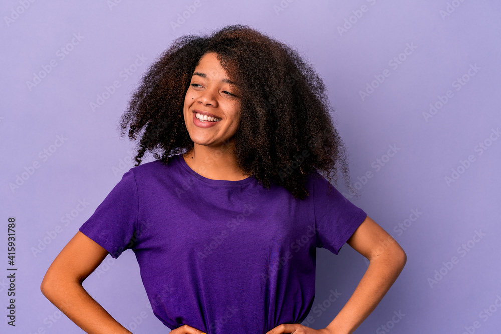 Young african american curly woman isolated on purple background confident keeping hands on hips. Young african american curly woman isolated on purple background confident keeping hands on hips.