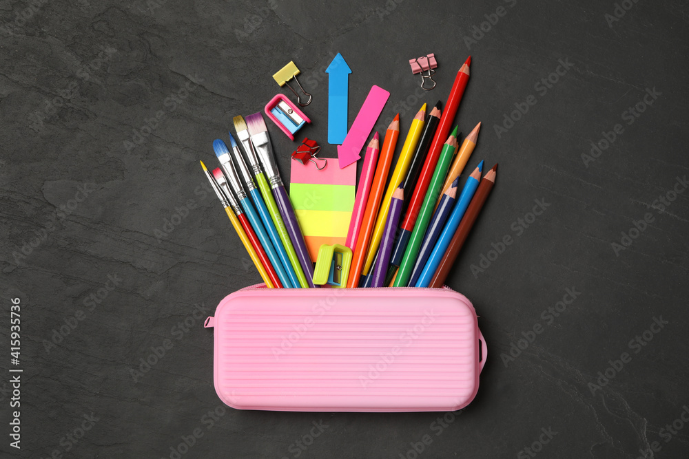 Fototapeta premium Flat lay composition with different school stationery on black stone table. Back to school