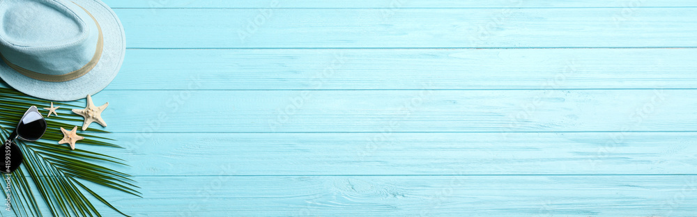 Fototapeta premium Beach accessories and space for text on light blue wooden background, flat lay. Banner design