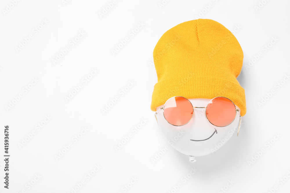 Funny face made of balloon, hat and sunglasses on white background, top view. Space for text Funny face made of balloon, hat and sunglasses on white background, top view. Space for text