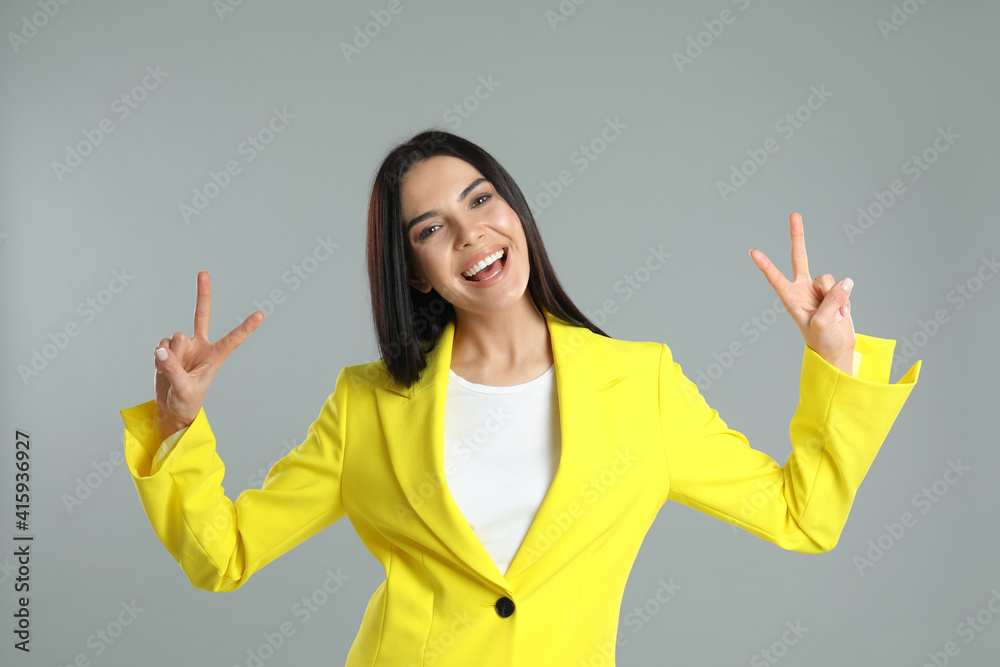 Woman showing number four with her hands on grey background Woman showing number four with her hands on grey background