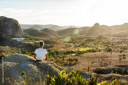 Foto Mulher meditando em cima da montanha ao por do sol