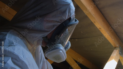 Man in respirator mask making thermal roof insulation. Full-face protection