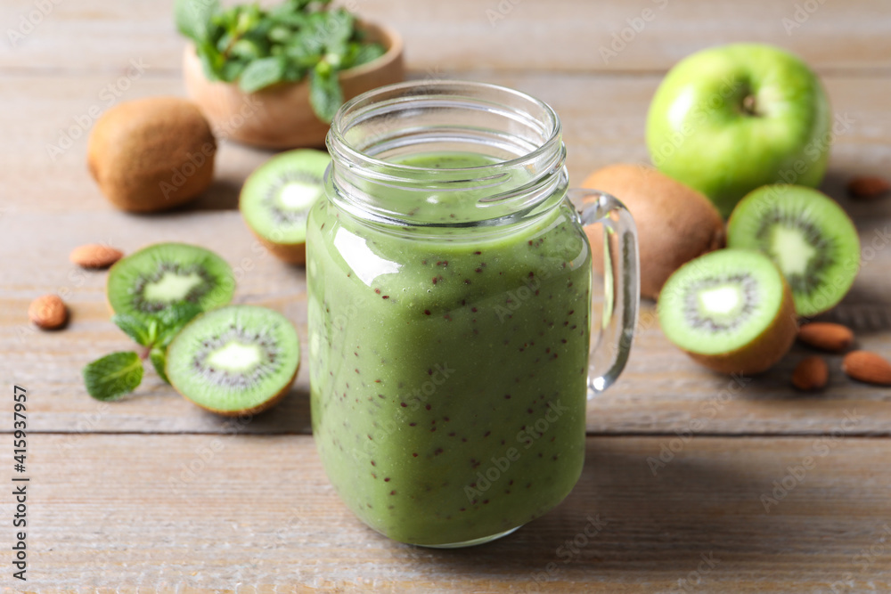 Delicious kiwi smoothie and fresh fruits on wooden table