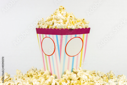 Colored striped square box of popcorn on a white background