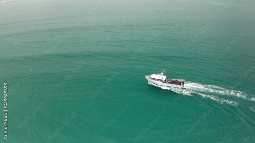 Aerial view of a ferry driving on the coast of the Seal island, cloudy day, in Australia - tracking, drone shot Aerial view of a ferry driving on the coast of the Seal island, cloudy day, in Australia - tracking, drone shot