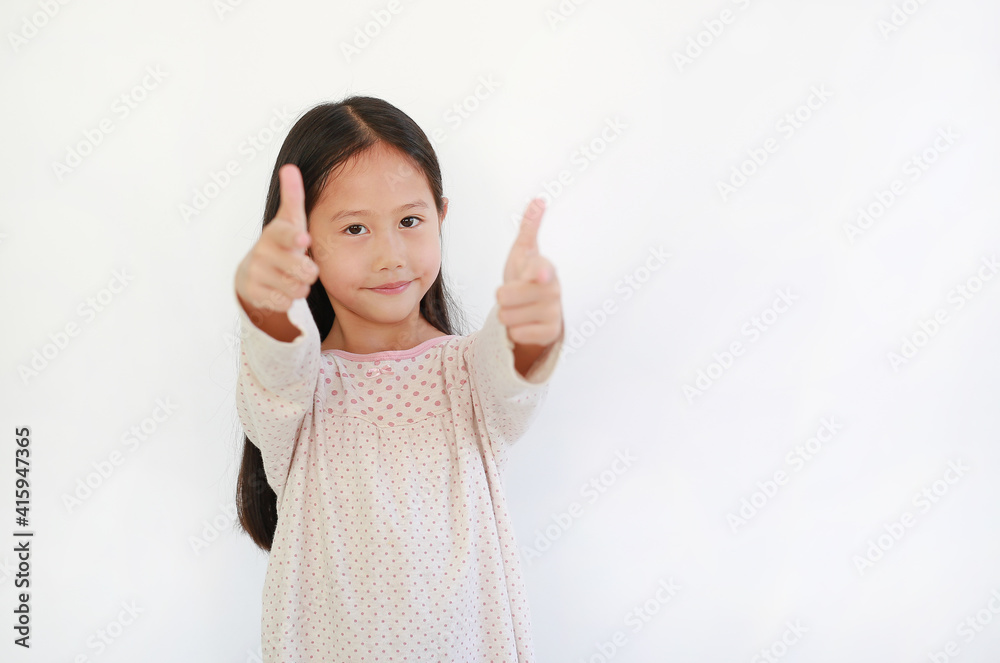 Smiling Asian little child girl child pointing at you and looking camera isolated on blue background. Kid point two index fingers to front Smiling Asian little child girl child pointing at you and looking camera isolated on blue background. Kid point two index fingers to front