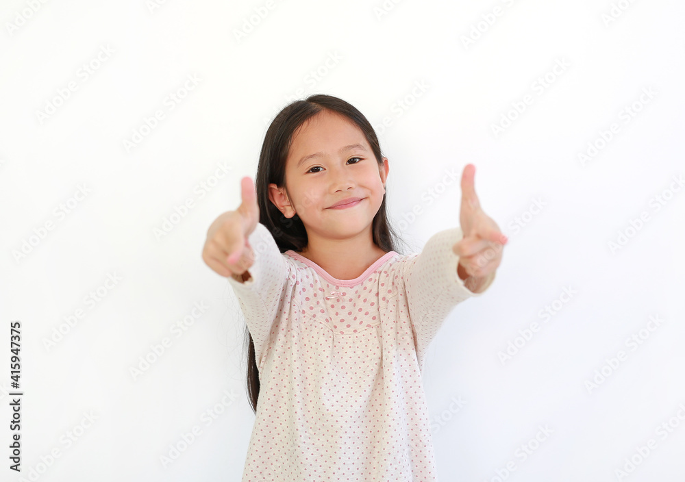 Smiling Asian little child girl child pointing at you and looking camera isolated on blue background. Kid point two index fingers to front Smiling Asian little child girl child pointing at you and looking camera isolated on blue background. Kid point two index fingers to front