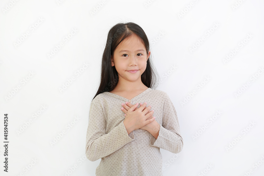 Portrait of Asian little girl holding hands on heart gesture of love. Kid place arms on chest isolated on white background. Portrait of Asian little girl holding hands on heart gesture of love. Kid place arms on chest isolated on white background.