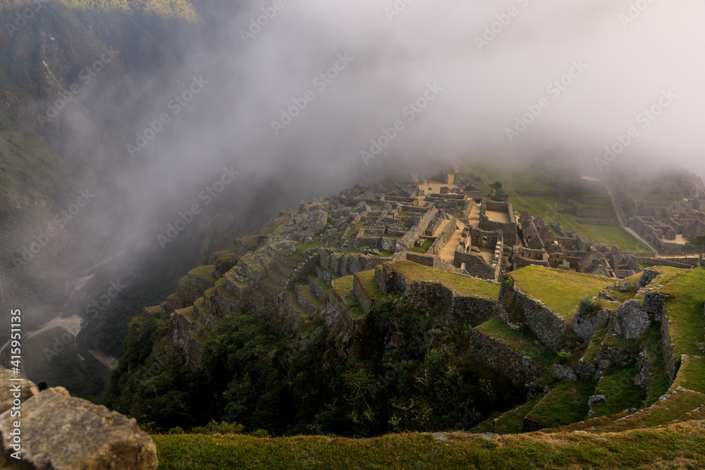 The old Inca city-temple of Machu Picchu surrounded by a cloud of fog