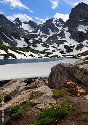 magnificent arapahoe  navajo  and shoshoni peaks with a mountain stream and snowfield on a sunny summer day along the lake isabele trail in the indian peaks wilderness area near nederland  colorado