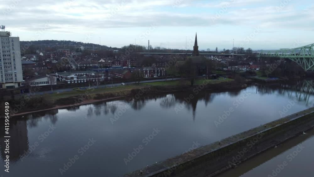 Runcorn old town waterfront aerial view suburban residential property housing and church spire district slow right dolly Runcorn old town waterfront aerial view suburban residential property housing and church spire district slow right dolly