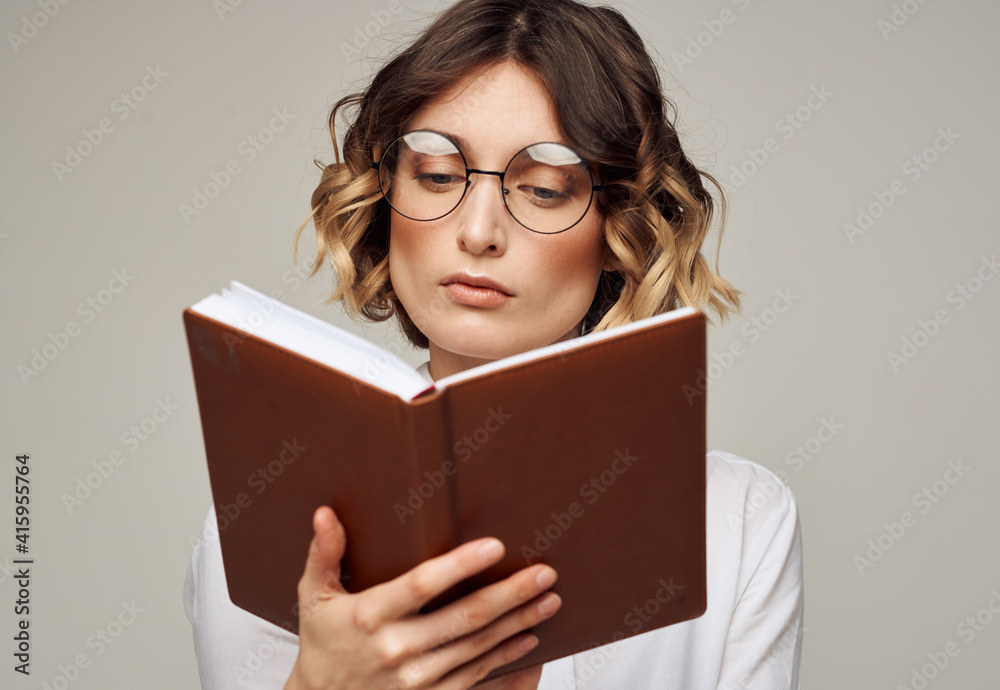 Literate woman with book in hands and in glasses white shirt education model Literate woman with book in hands and in glasses white shirt education model