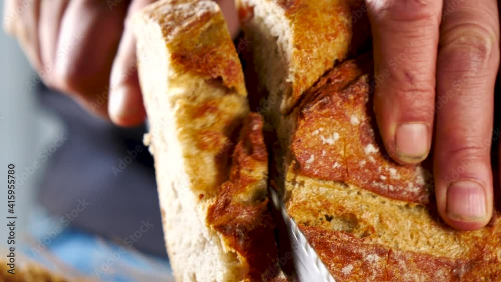 man cutting slice of bread