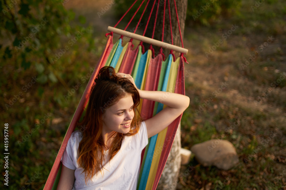 happy woman lies in a hammock outdoors in the forest laughing happy woman lies in a hammock outdoors in the forest laughing