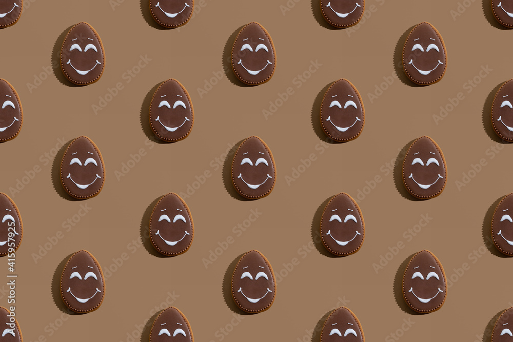 Easter pattern. Seamless banner. Festive pastry art. Homemade cookies. Abstract background. Sweet bakery with chocolate icing and white smiling face decoration isolated on beige. Easter pattern. Seamless banner. Festive pastry art. Homemade cookies. Abstract background. Sweet bakery with chocolate icing and white smiling face decoration isolated on beige.