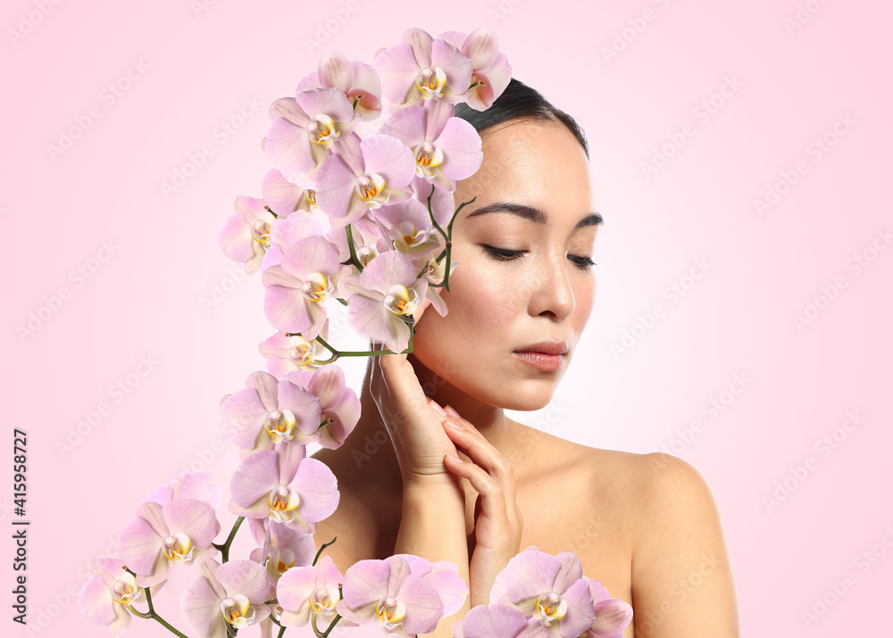 Portrait of young Asian woman with beautiful orchid flowers on color background Portrait of young Asian woman with beautiful orchid flowers on color background