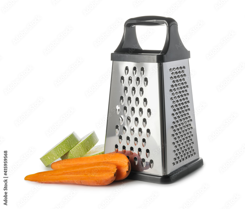 Metal grater, carrots and zucchini on white background Metal grater, carrots and zucchini on white background