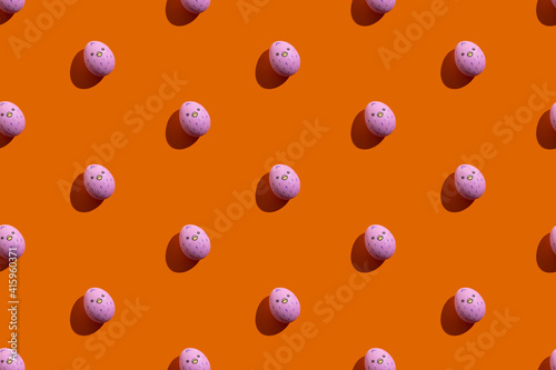Easter seamless pattern. Cute egg art. Festive decor. Holiday gift card. Abstract background. Pink paschal symbol with painted poult isolated on orange.