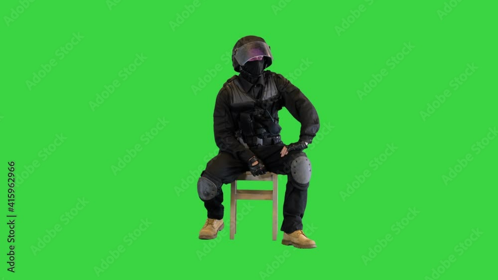 Policeman wearing face mask and high tech helmet sitting waiting, thinking on a Green Screen, Chroma Key. Policeman wearing face mask and high tech helmet sitting waiting, thinking on a Green Screen, Chroma Key.