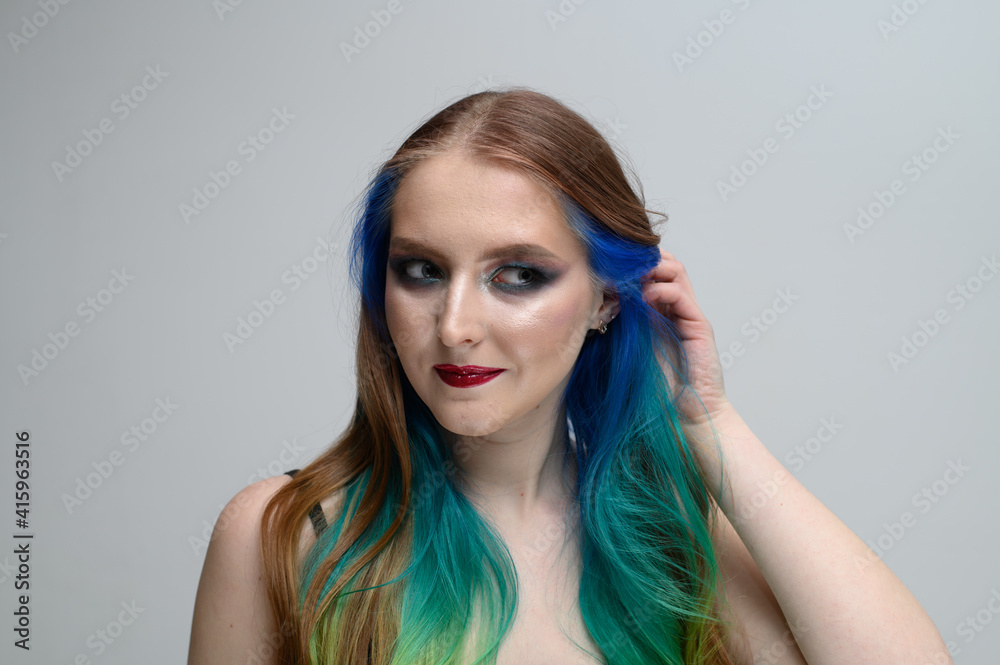 Portrait on a white background of a caucasian brunette model with long dyed hair and bright makeup Portrait on a white background of a caucasian brunette model with long dyed hair and bright makeup