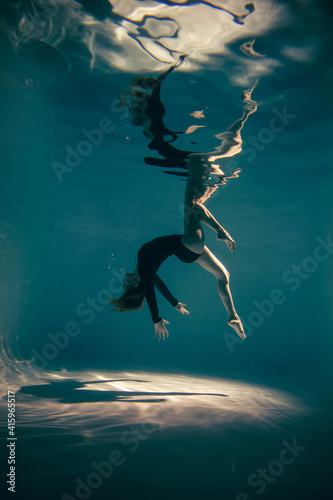 Underwater woman portrait in swimming pool.