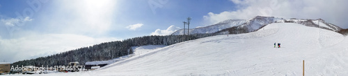 Panorama view of a ski resort with few people on a sunny day (Niseko, Hokkaido, Japan)
