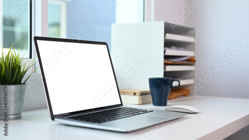 Close up view of computer laptop with blank screen on modern office desk.