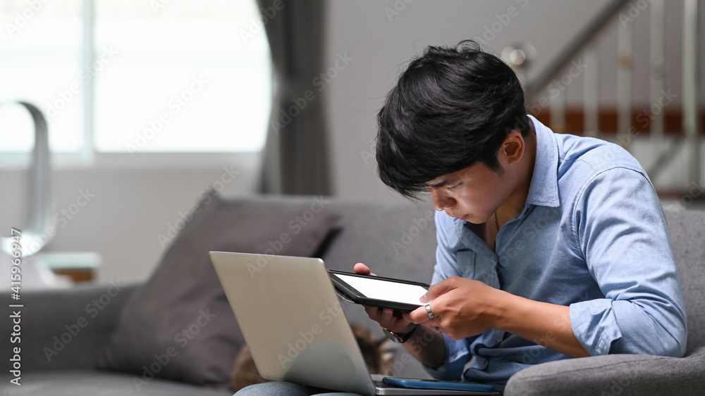 Businessman working online on laptop and using digital tablet at home. Businessman working online on laptop and using digital tablet at home.