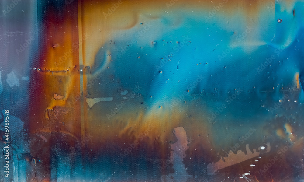 Fototapeta premium Colorful abstract background. Distressed texture. Wet distorted stained display with rainbow color gradient orange blue glitch defect dust scratches grain noise.
