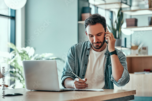 Focused businessman making notes in notebook at cafe